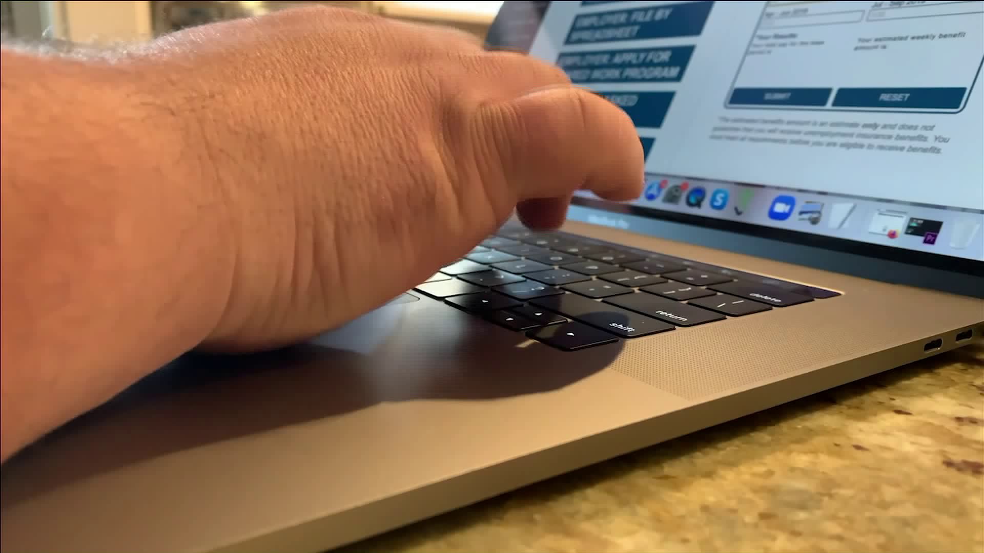 Picture of a woman's hand at a computer screen