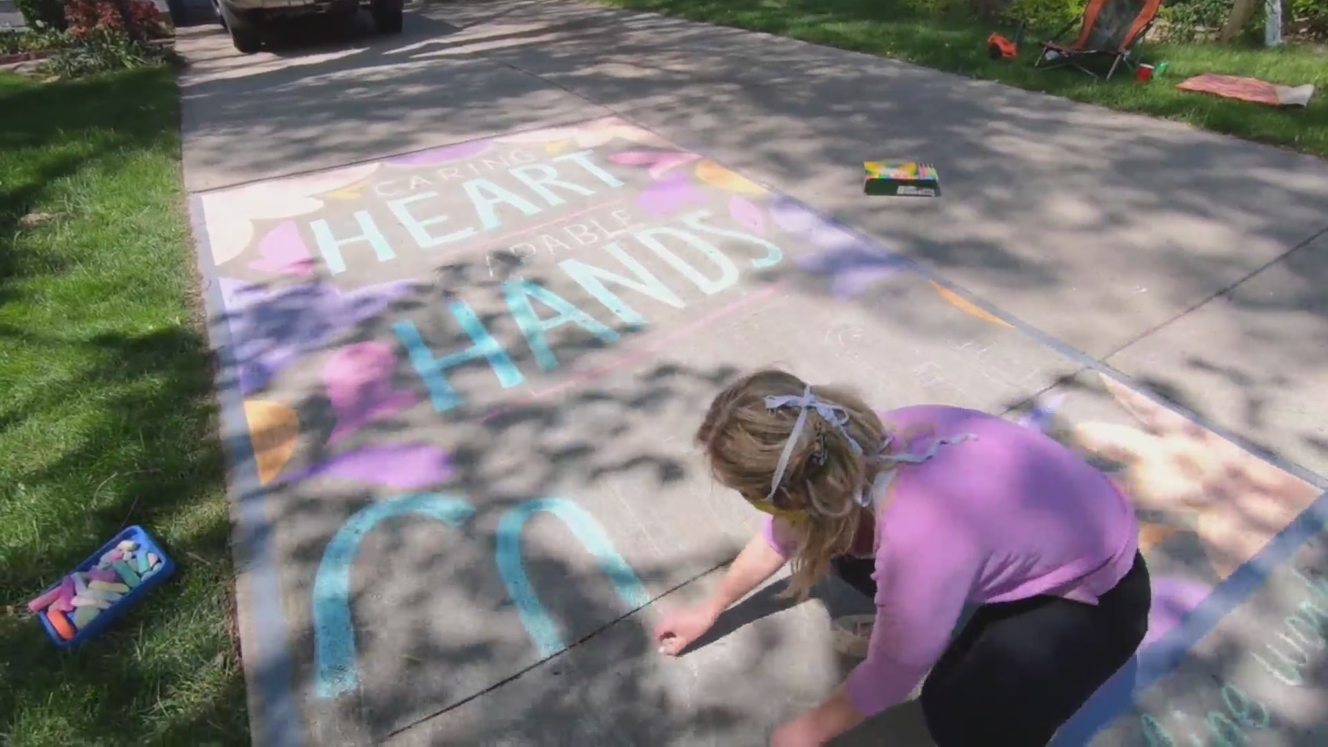 Picture of artist drawing on driveway