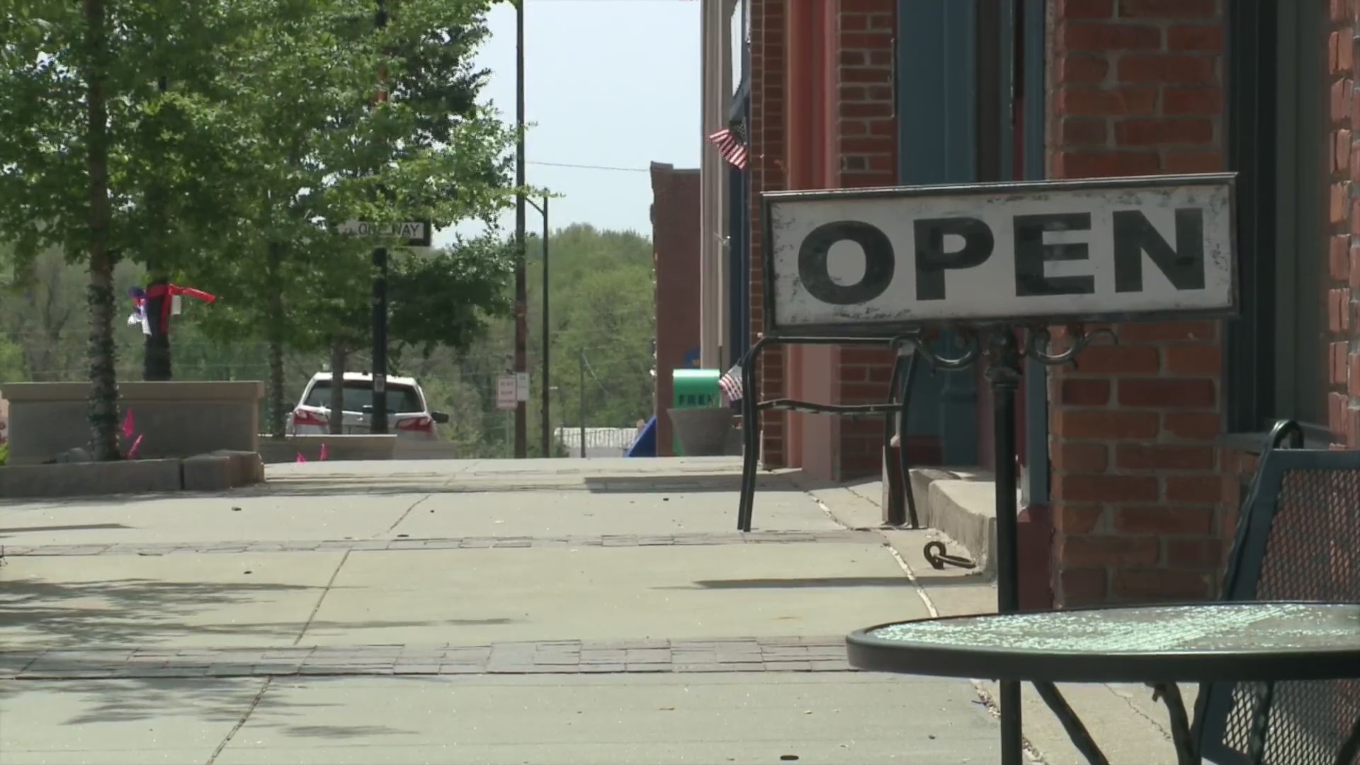 Picture of open sign with empty sidewalk