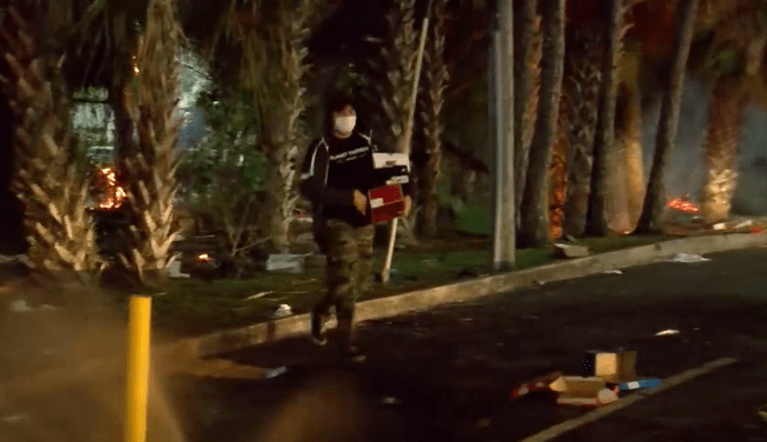 Picture of person carrying boxes during protests, looting